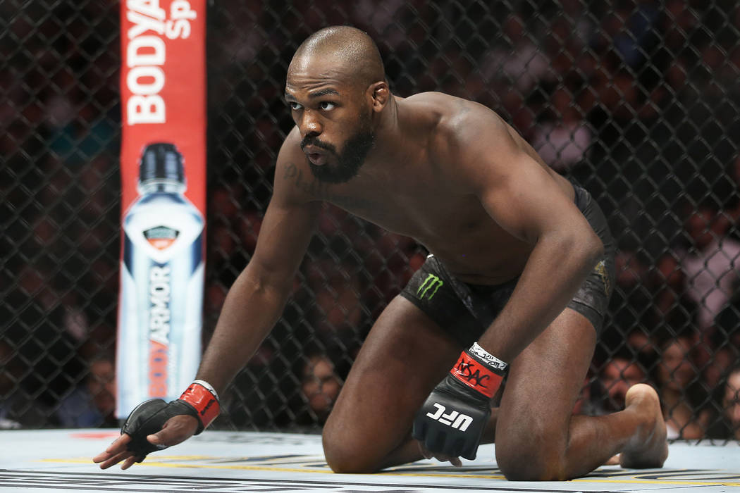 Jon Jones crawls towards the middle of the ring before the start of his light heavyweight title ...