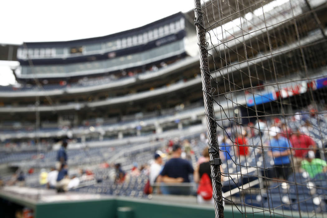 New netting separates the infield from lower bowl seating before a postponed baseball game ...