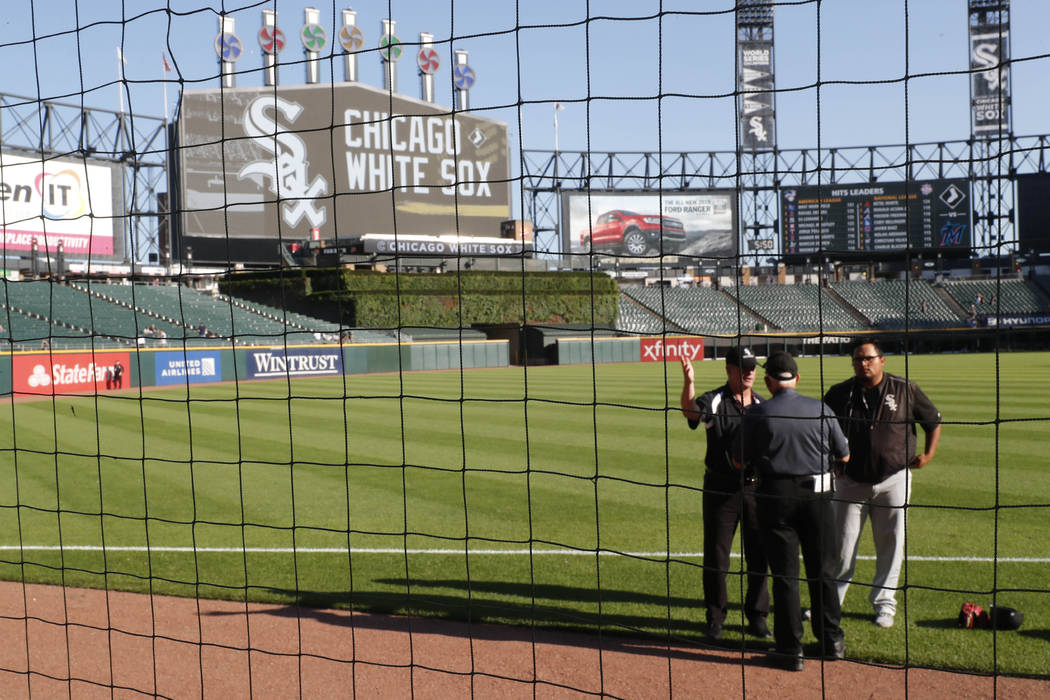 Security personnel at Guaranteed Rate Field are viewed through the newly extended protective ne ...
