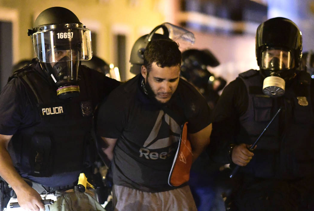 Police arrest a demonstrator during clashes demand the resignation of Gov. Ricardo Rossello in ...