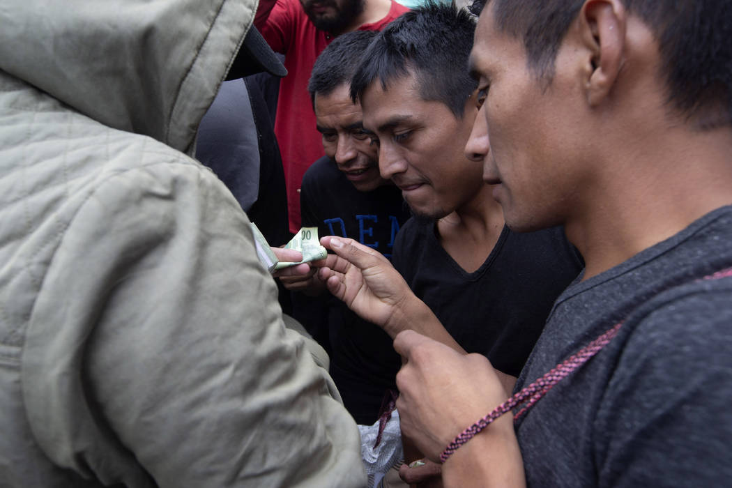 Guatemalan men who were deported from the United States, change money after arriving at the Air ...