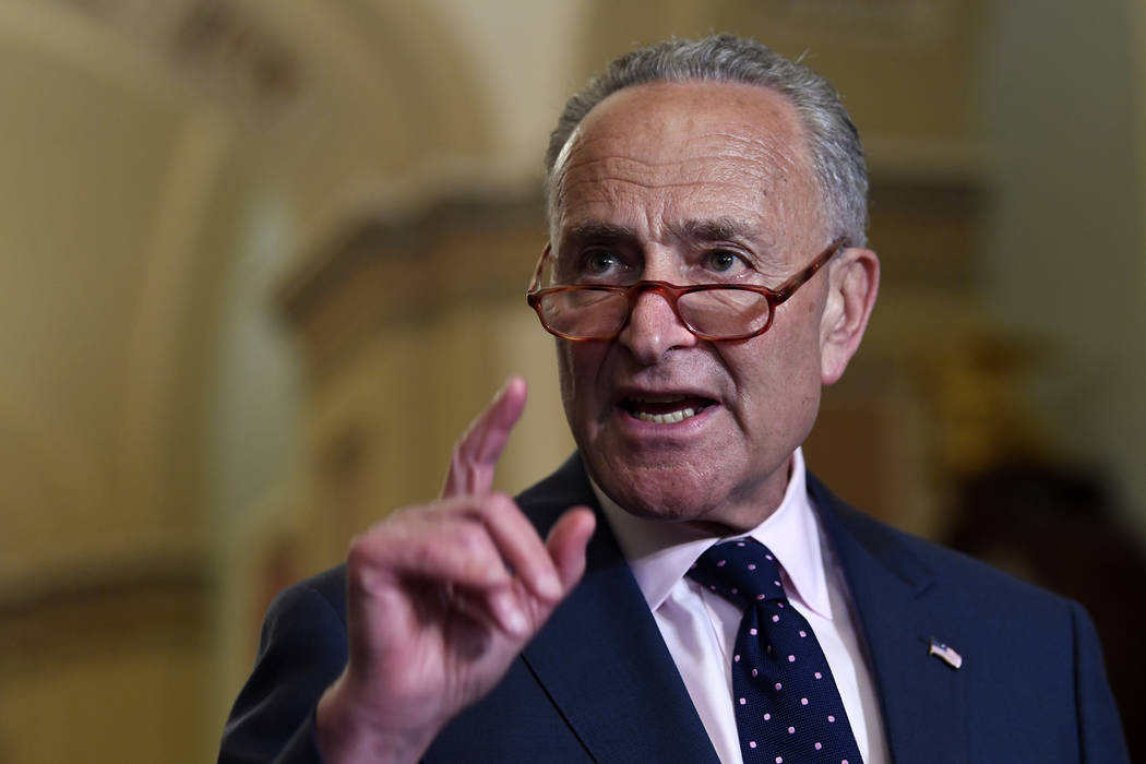 Senate Minority Leader Sen. Chuck Schumer of N.Y., center, speaks to reporters following the we ...