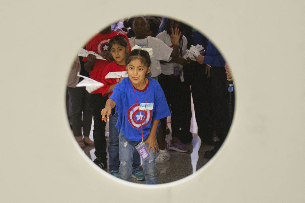 Maria Garcia, 8, attempts to land a paper plane through a hole during the seventh annual Paper ...