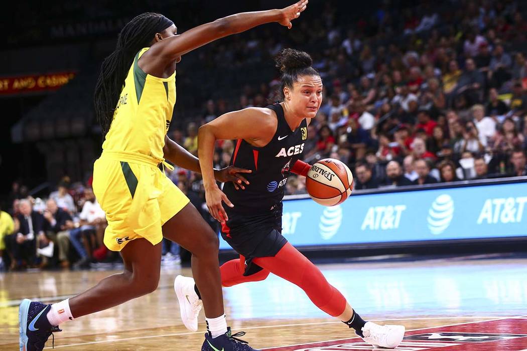 Las Vegas Aces' Kayla McBride, right, drives to the basket past Seattle Storm's Crystal Langhor ...