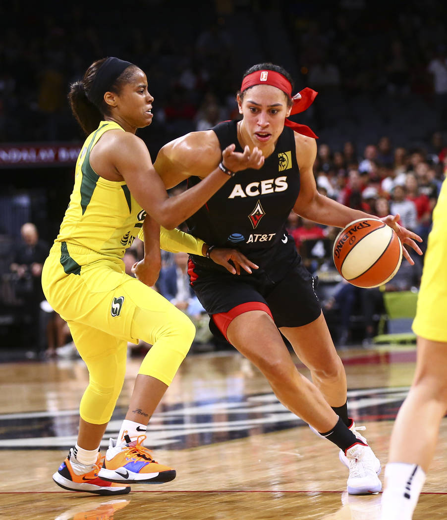 Las Vegas Aces' Dearica Hamby (5) drives to the basket past Seattle Storm's Jordin Canada durin ...