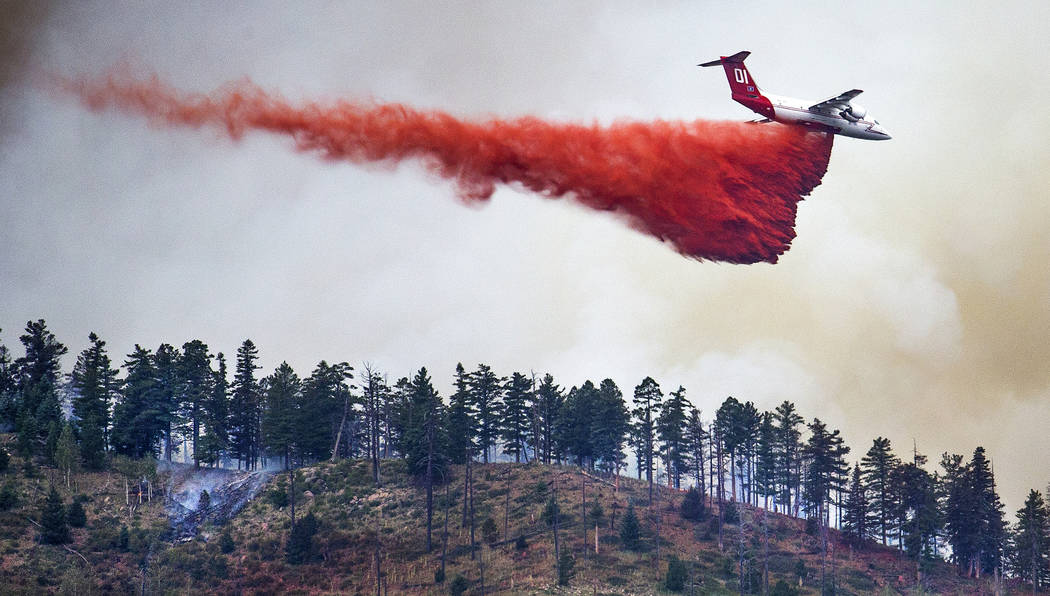 In this Monday, July 22, 2019, photo, an air tanker drops retardant on a ridge overlooking the ...