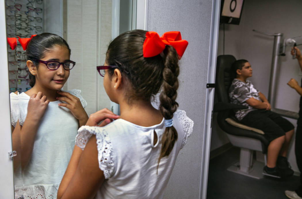 Esther Espinoza, 10, checks herself out in the mirror with wearing a new pair of glasses during ...