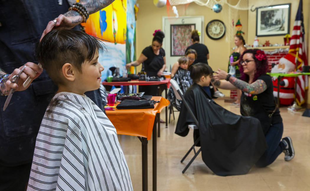 Toby Lewis, 5, from left, has his hair cut by stylist Ryan Glassford as Kaleb Lewis, 4, has his ...