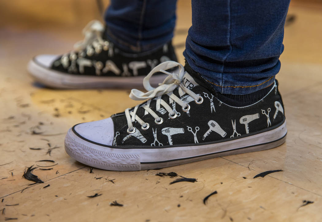 Hair stylist Sara Burton wears her custom sneakers while volunteering during a back-to-school e ...