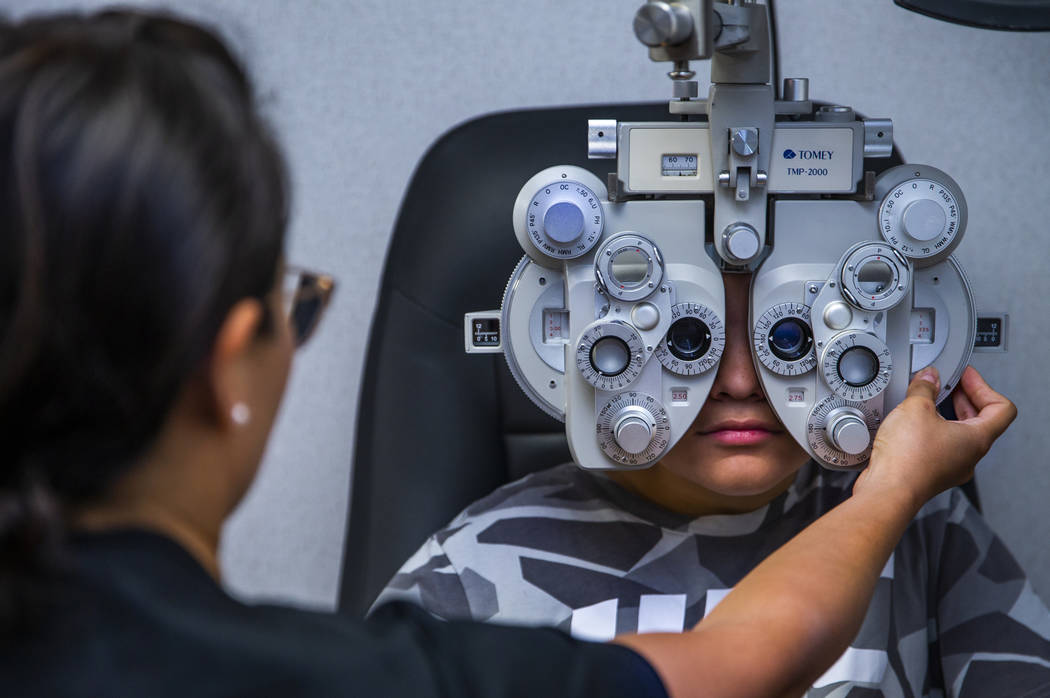 Dr. Silvia Park, left, checks the eyes of Santiago Salvano, 13, during a back-to-school event a ...