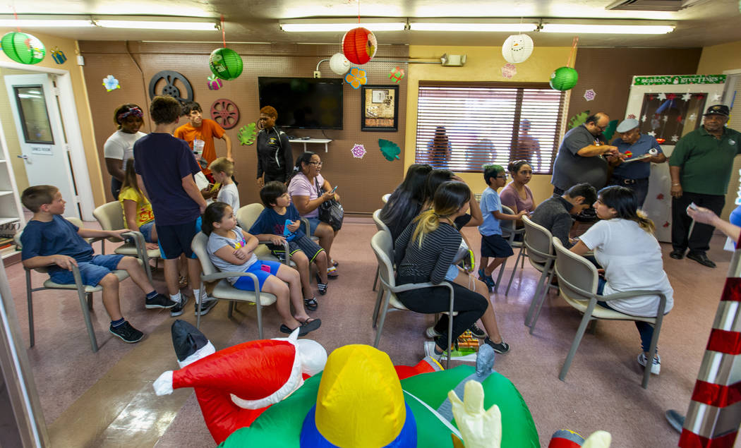 The haircut waiting area is full during a back-to-school event with free haircuts, eye exams an ...