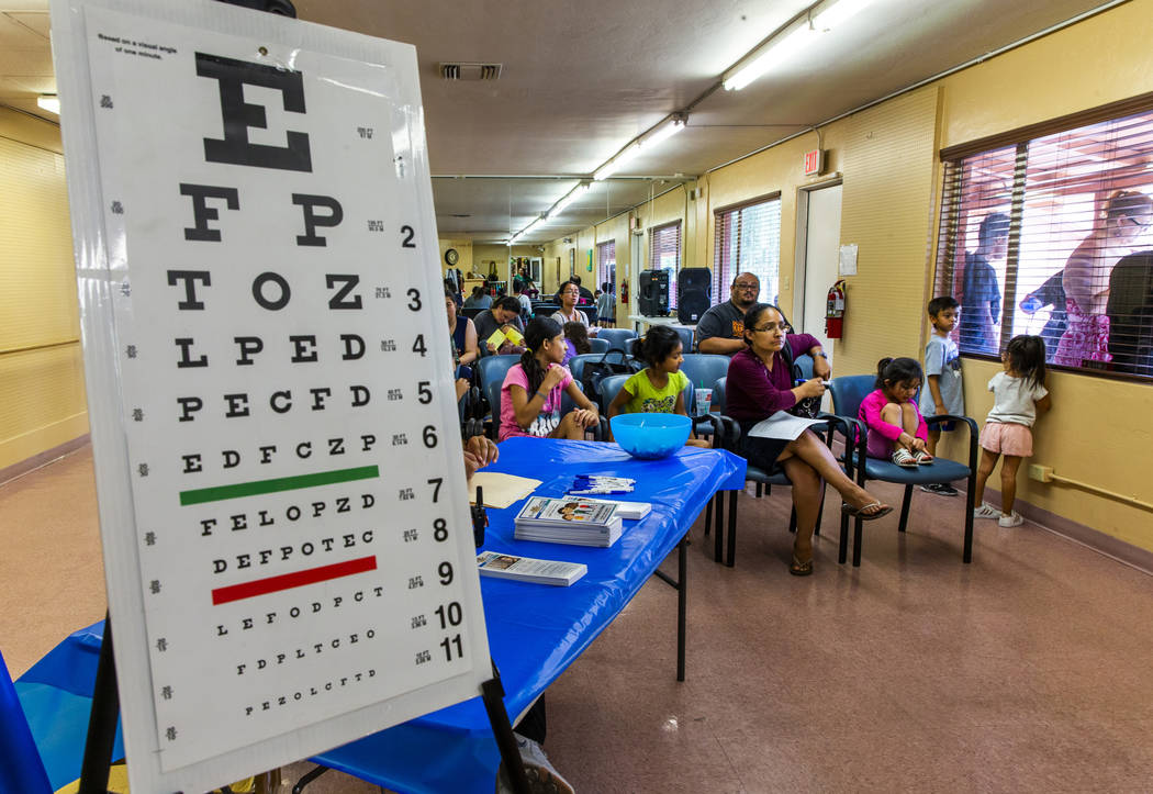 Students with parents await their turn for eye exams during a back-to-school event at the Derfe ...