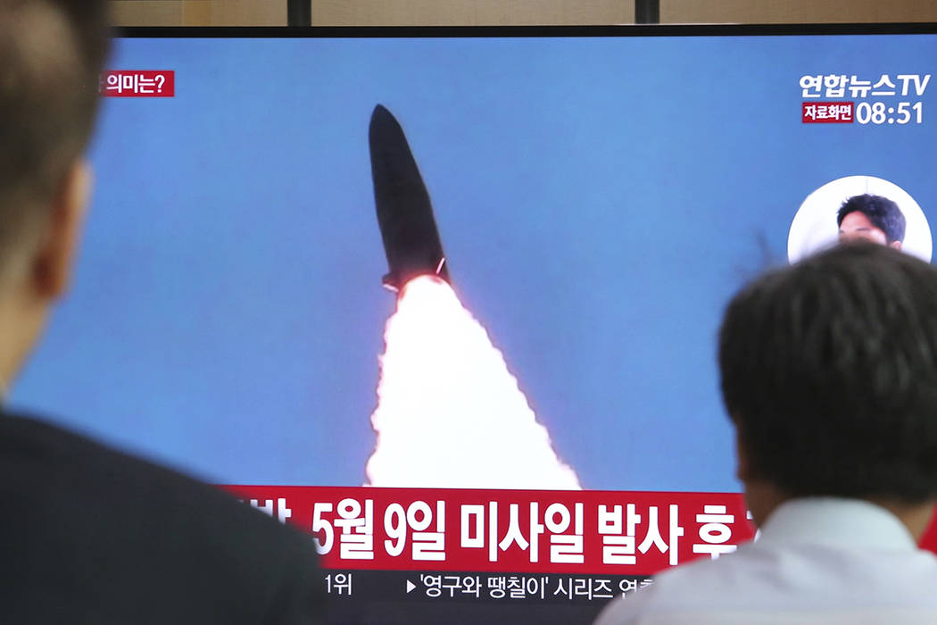 People watch a TV showing a file image of North Korea's missile launch during a news program at ...