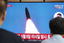 People watch a TV showing a file image of North Korea's missile launch during a news program at ...