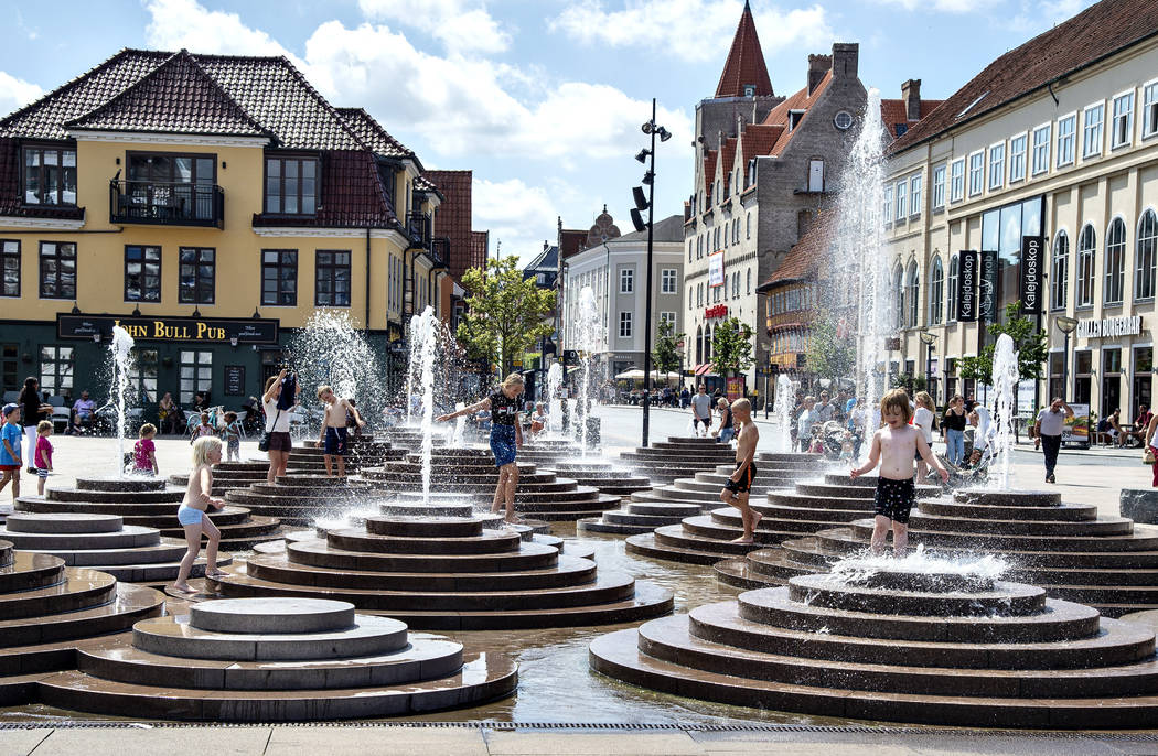 People cool down in the fountains as temperatures reached 30 degrees Celsius, at Toldbod Plads ...