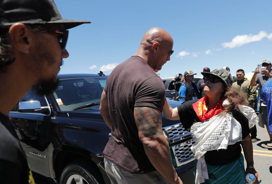 Actor Dwayne "The Rock" Johnson, center, greets community leader Pua Case as oppositi ...