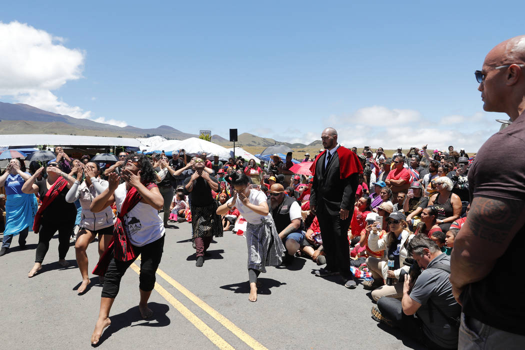 Actor Dwayne "The Rock" Johnson watches a kahiko performance during a visit to the pr ...