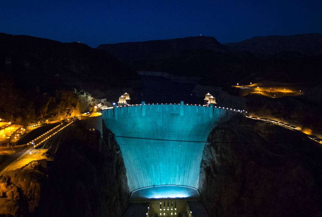 Hoover Dam, lit up turquoise to promote lung cancer awareness, as seen from O'Callaghan-Tillman ...