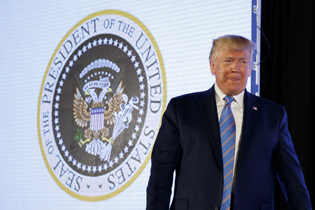 President Donald Trump arrives to speak, with an altered presidential seal behind him, at Turni ...