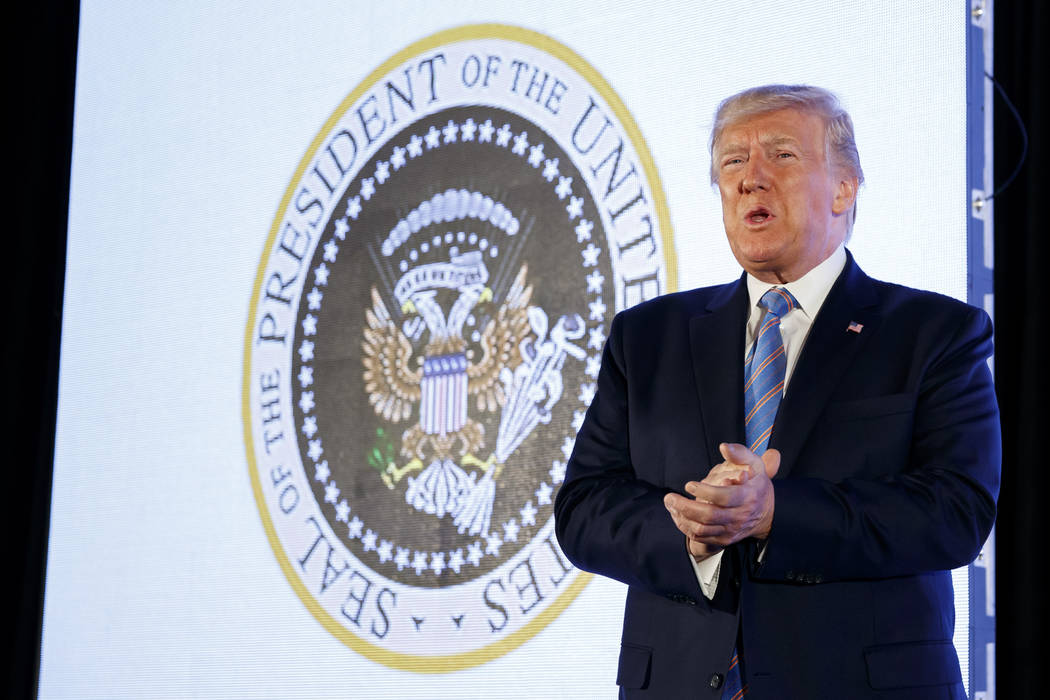 President Donald Trump arrives to speak, with an altered presidential seal behind him, at Turni ...