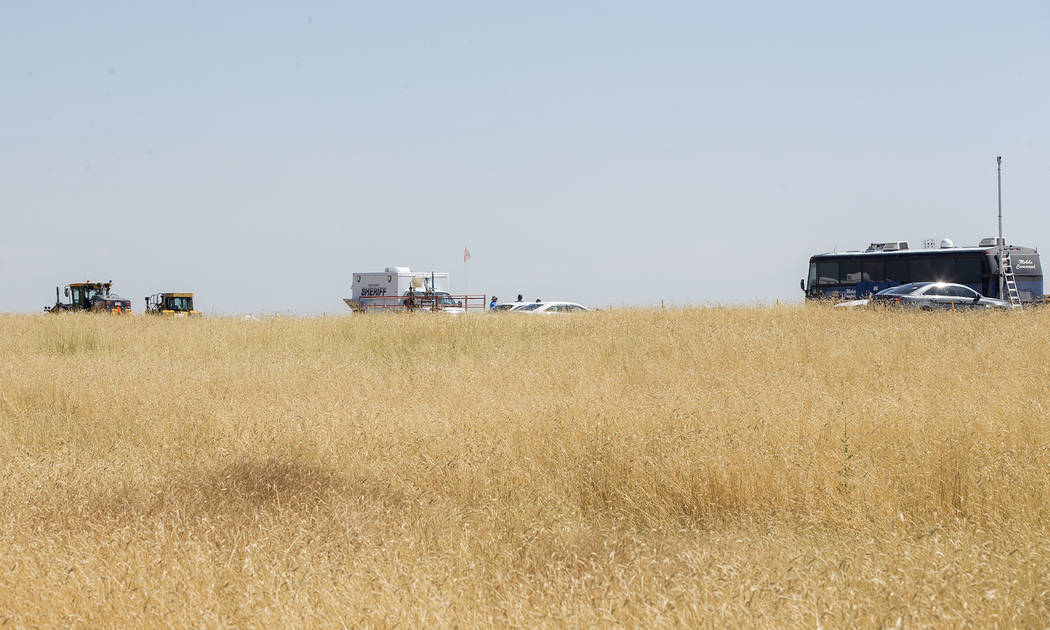 In this photo taken Wednesday, July 24, 2019, authorities investigate the scene in the distance ...