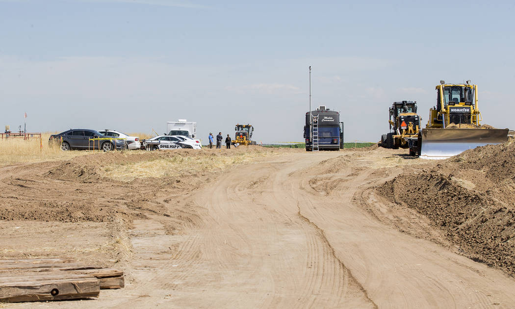 In this photo taken Wednesday, July 24, 2019, authorities investigate the scene in the distance ...