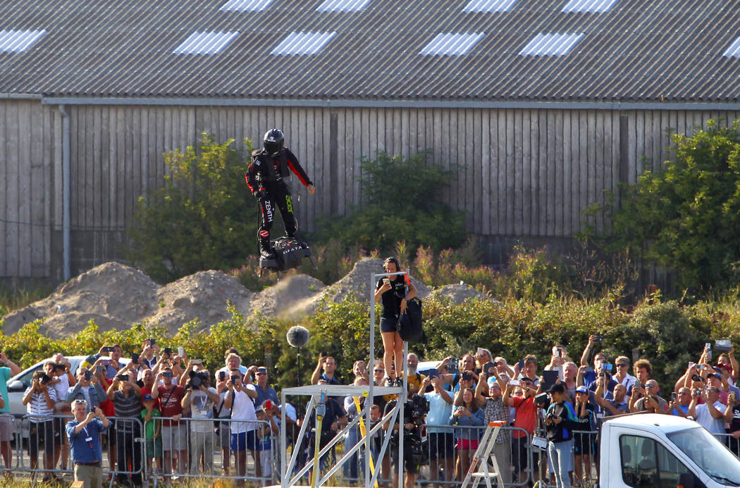 Onlookers observe the take-off as Franky Zapata, a 40-year-old inventor, lifts off in Sangatte, ...