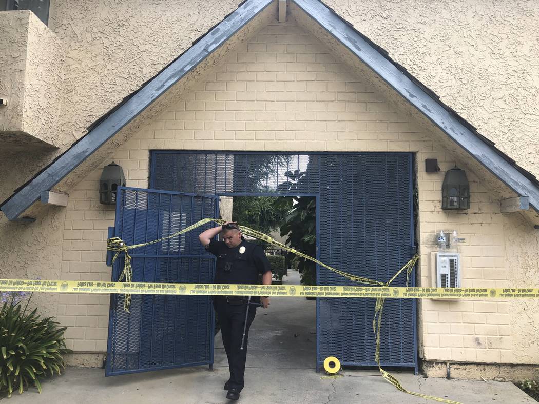 A Los Angeles police officer walks out of an apartment where a shooting occurred in the Canoga ...