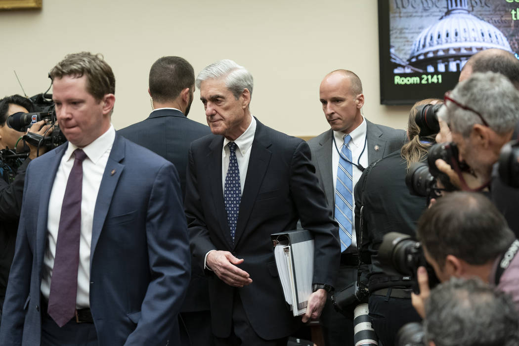 Escorted by a security detail, former special counsel Robert Mueller arrives to testify to the ...