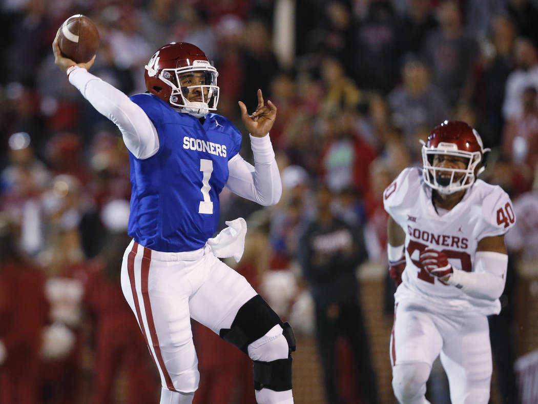 Oklahoma quarterback Jalen Hurts (1) passes under pressure from linebacker Jon-Michael Terry (4 ...