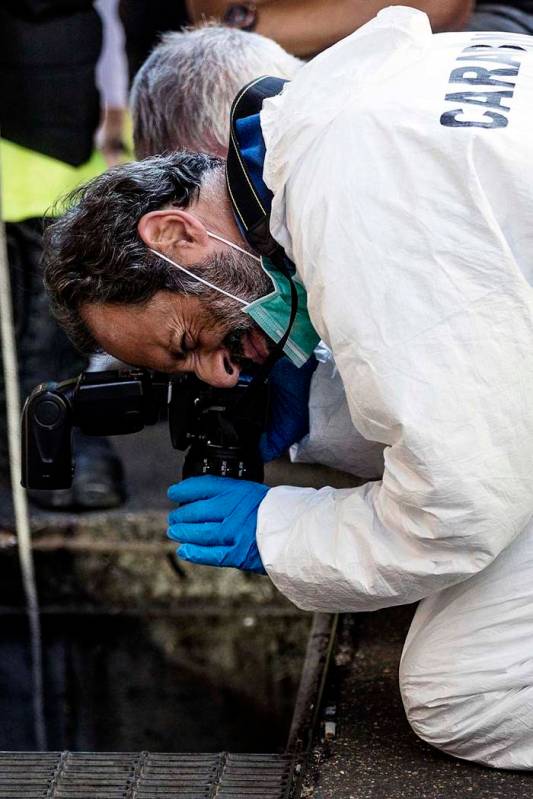 In this picture taken Friday, July 26, 2019 investigators are seen on the scene where an Italia ...