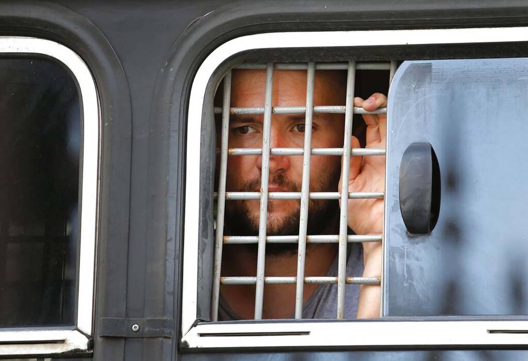 A detained protester looks out of a police bus window prior to an unsanctioned rally in the cen ...