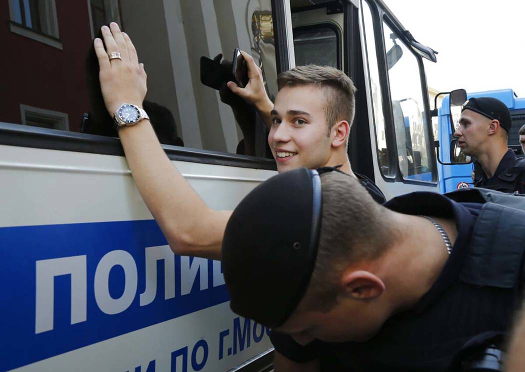 Police officers detain a man prior to an unsanctioned rally in the center of Moscow, Russia, Sa ...