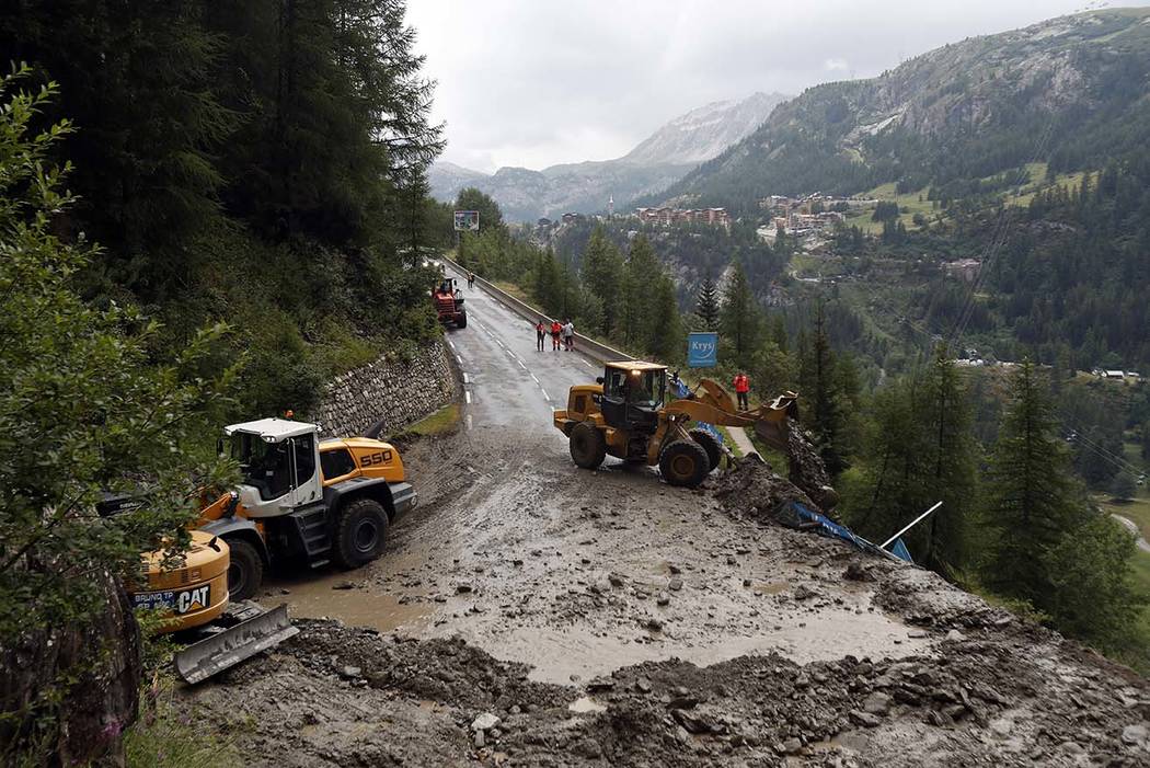 Worker use diggers to clean the road of the nineteenth stage of the Tour de France cycling race ...