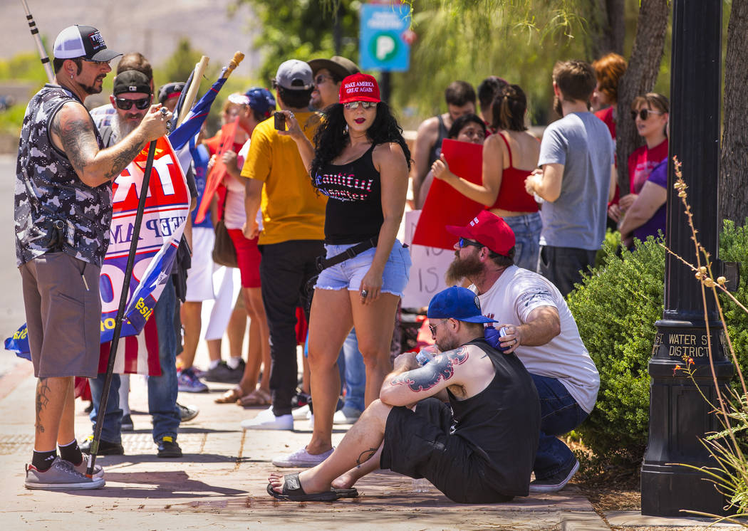 Counter protester Corey Allen, bottom center, is attended to by others due to excessive heat ex ...