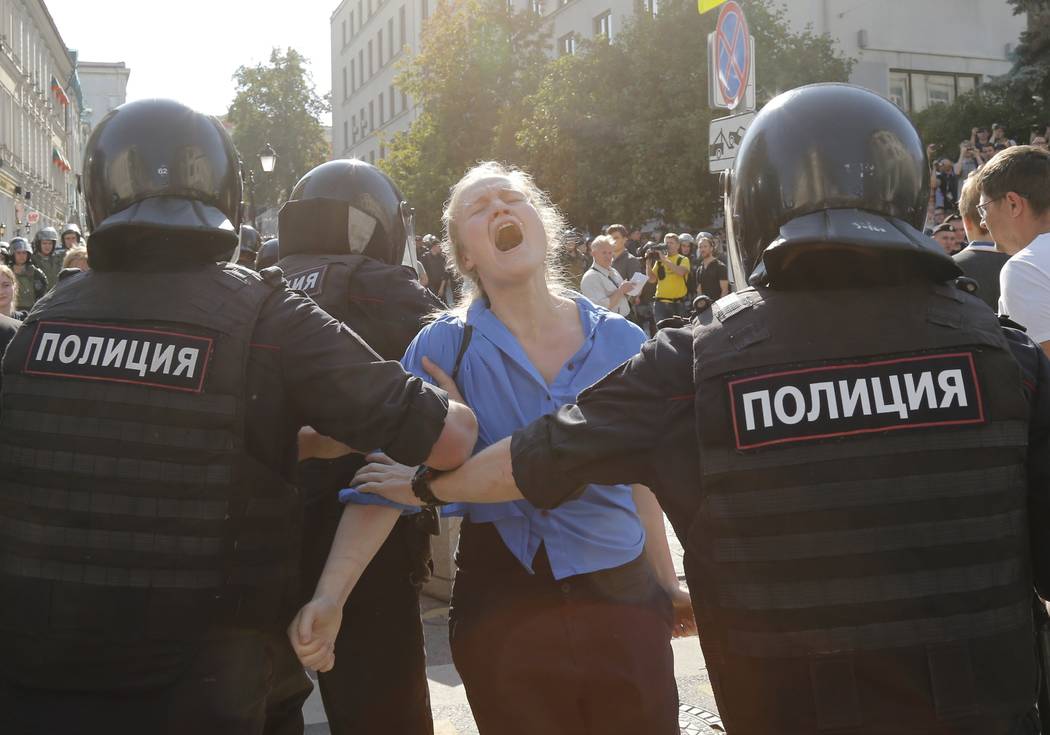 Police officers detain a woman during an unsanctioned rally in the center of Moscow, Russia, Sa ...