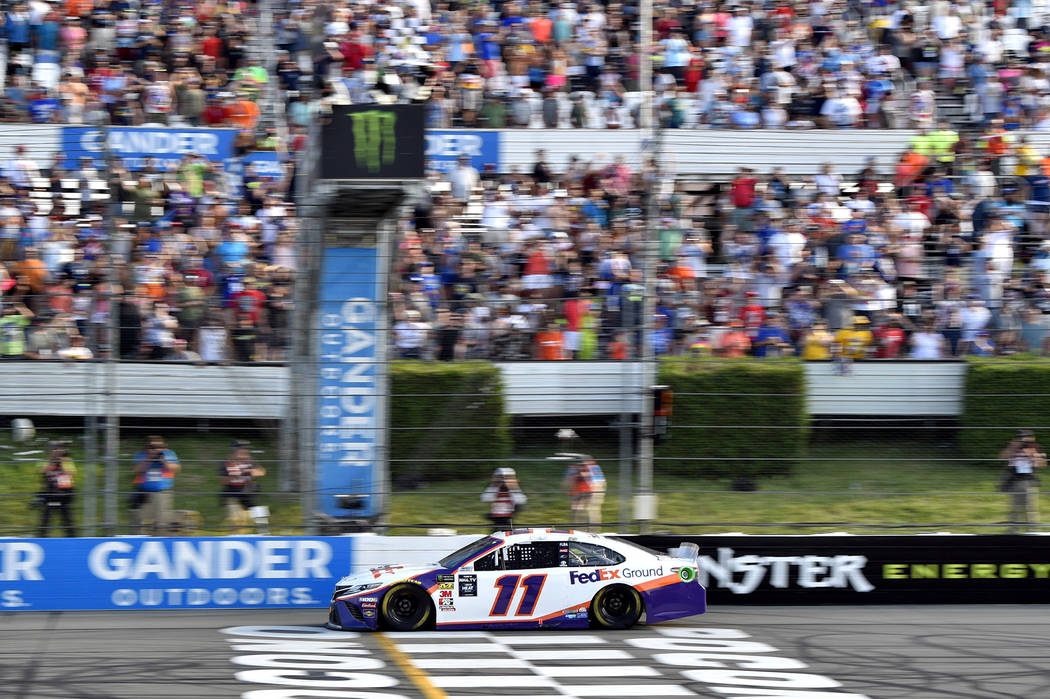 Denny Hamlin crosses the finish line to win a NASCAR Cup Series auto race, Sunday, July 28, 201 ...