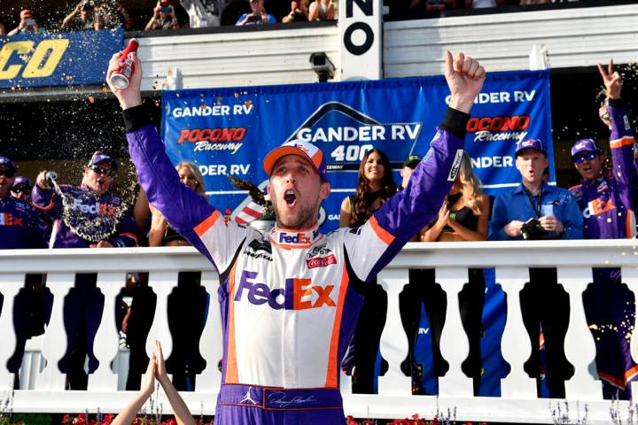 Denny Hamlin celebrates in Victory Lane after winning a NASCAR Cup Series auto race, Sunday, Ju ...