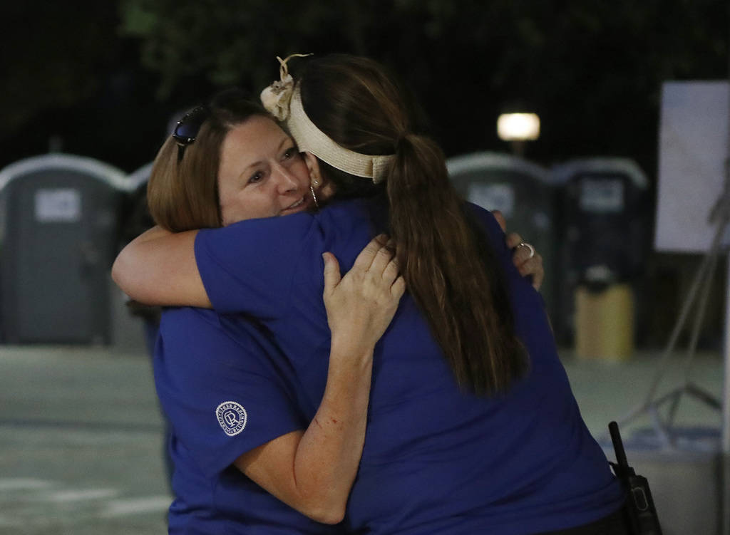 Gilroy Garlic festival volunteer Denise Buessing, left, embraces fellow volunteer Marsha Struzi ...