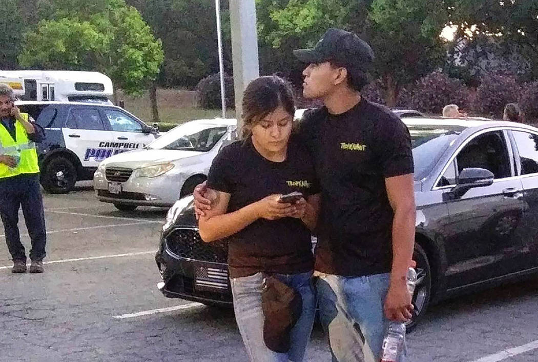 A young couple embrace at a parking lot after a shooting at the Gilroy Garlic Festival in Gilro ...