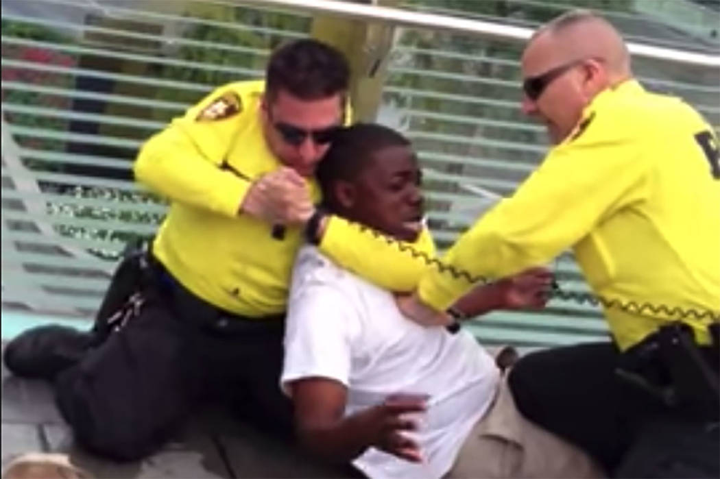 A screenshot from a 2013 video shows two Las Vegas police officers apprehending a man on the La ...