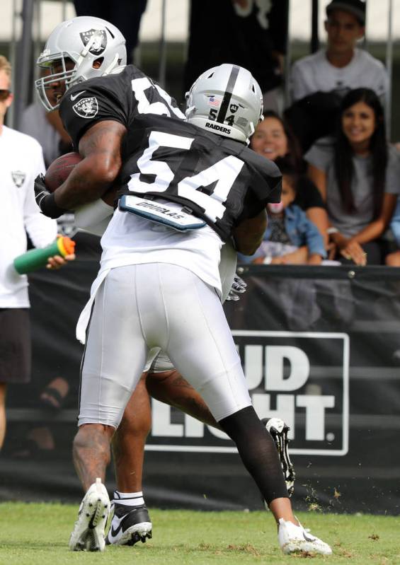 Oakland Raiders inside linebacker Brandon Marshall (54) tackles outside linebacker Vontaze Burf ...