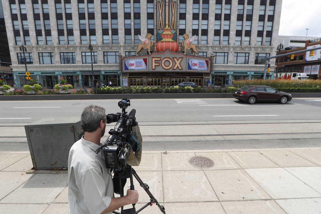 A cameraman gathers footage outside the Fox Theatre displaying signs for the Democratic preside ...