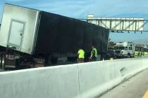 Workers inspect a semi involved in a crash at Interstate 215 and Gibson Road on Tuesday, July 3 ...