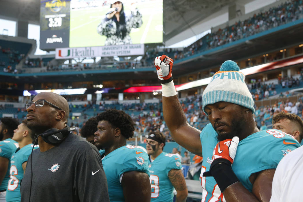 Miami Dolphins defensive end Robert Quinn (94) raises his right fist during the singing of the ...