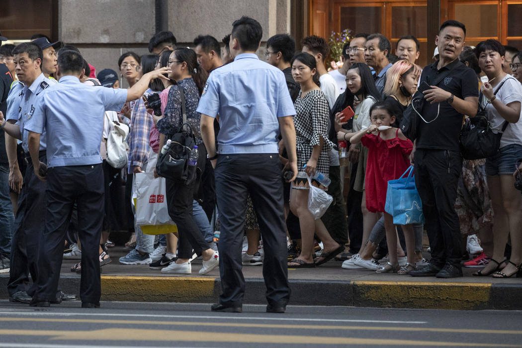 Police try to get the crowd to move on ahead of the arrival of the U.S. Trade delegation at the ...