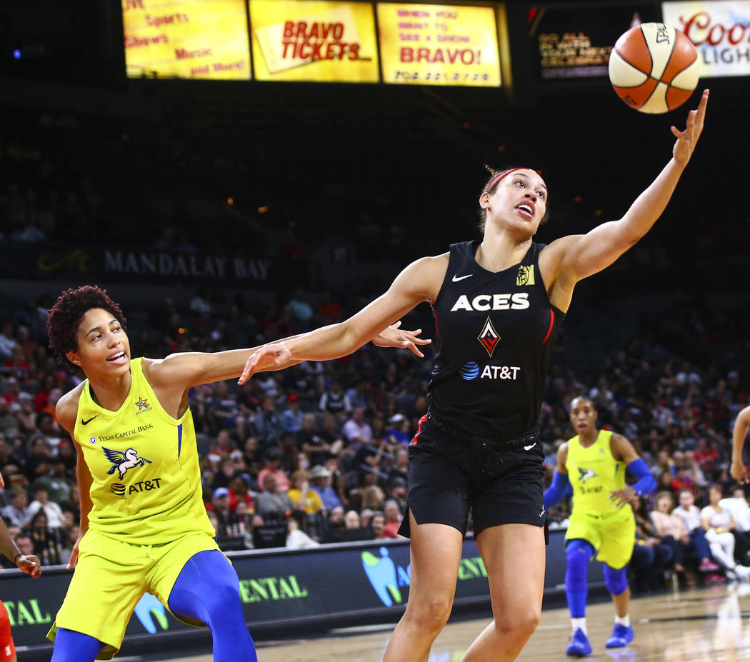 Las Vegas Aces' Dearica Hamby, right, gets a rebound in front of Dallas Wings' Isabelle Harriso ...