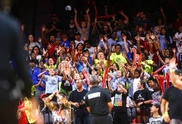 Las Vegas Aces fans reach for free items during the second half of a WNBA basketball game betwe ...