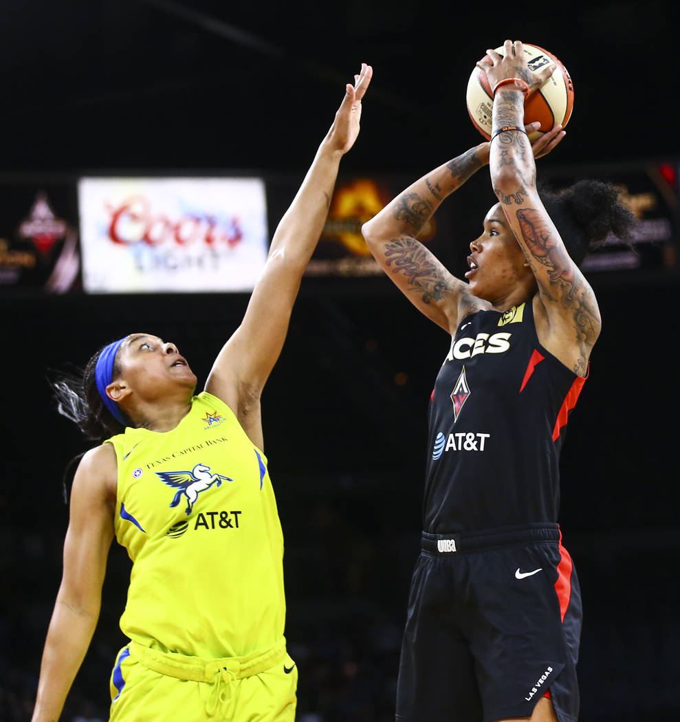 Las Vegas Aces' Tamera Young shoots over Dallas Wings' Allisha Gray during the second half of a ...