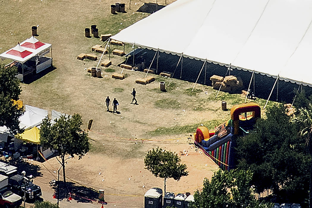 Investigators examine an area by an inflatable slide at Christmas Hill Park, the scene of Sunda ...